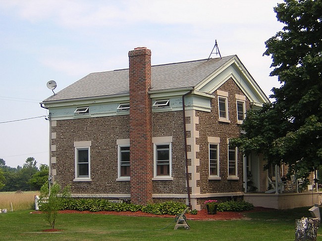 Greek Revival style farmhouse with pebble-array facing